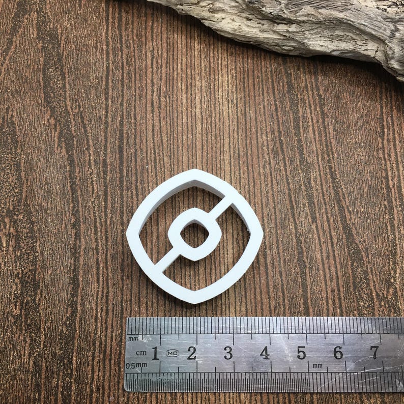 以下が含まれることがあります： 中央に線が引かれた円形の白いプラスチック製のクッキーカッター。カッターの直径は約5cmです。