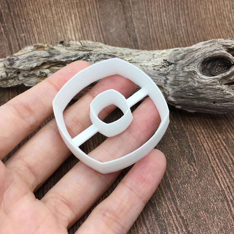 以下が含まれることがあります： 中央に穴の開いたドーナツの形をした白いプラスチック製のクッキーカッター