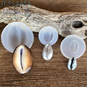 May include: An assortment of seashell molds and finished shells. The molds are clear, and the shells are silver and brown. The image includes the text "JESSAMA DESIGN" in the upper left corner.