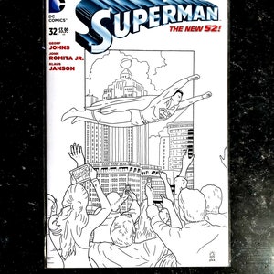 Puede incluir: Portada de cómic en blanco y negro con Superman volando sobre una ciudad con gente mirando hacia arriba. El texto de la portada dice "Superman The New 52!" e incluye el número del número y el precio.