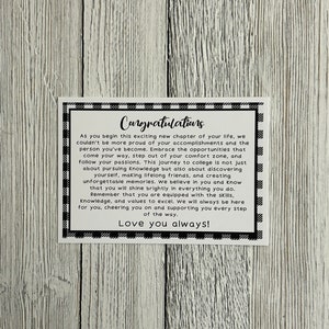 K&ouml;nnte beinhalten: Eine wei&szlig;e Karte mit schwarzem Rand und dem Wort "Congratulations" in einer Schreibschrift. Die Karte enth&auml;lt eine Botschaft der Unterst&uuml;tzung und Ermutigung, mit den Worten "Love you always!" unten.