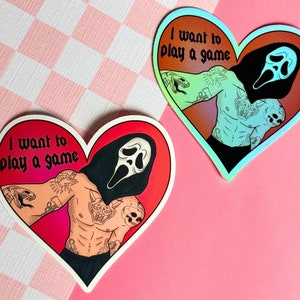 May include: Two heart-shaped stickers with a red and green gradient. The stickers feature a masked figure with a scream face and the text "I want to play a game".