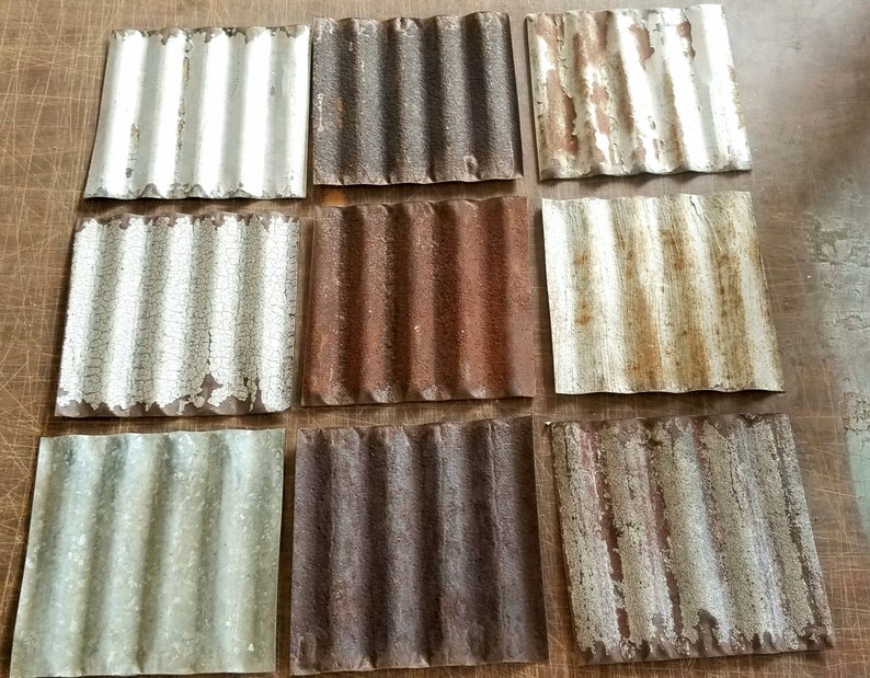 May include: Nine rusty metal squares with corrugated surfaces. The squares are arranged in three rows of three. Some of the squares have white paint that is peeling off, revealing the rusty metal underneath.