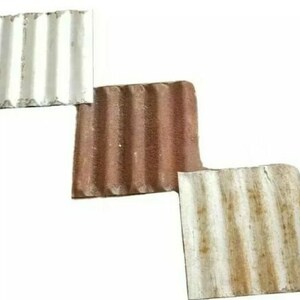 May include: Three corrugated roof tiles, one white, one brown, and one white with brown rust stains.