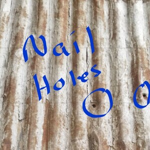 May include: Close-up of a rusty corrugated metal surface with blue painted text that reads "Nail Holes" and two blue circles with nail holes in the center.