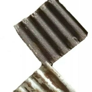 May include: Three diamond-shaped pieces of corrugated metal with a rustic, weathered look. The metal is painted in shades of white, gray, and brown, with some rust showing through.