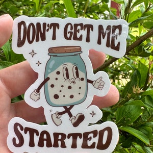 May include: White sticker with brown text that reads "Don't get me started". A cartoon illustration of a blue jar with a brown lid and white polka dots is walking. The jar has googly eyes and a smile.