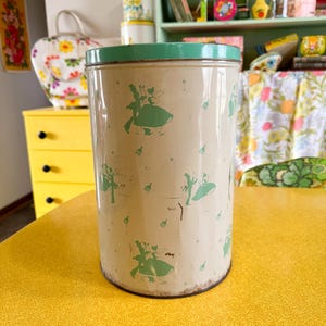 May include: A white ceramic mug with a black handle and the text "But First, Coffee" in a black, handwritten-style font. The mug is on a white surface.