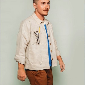 May include: A man wearing a beige jacket with a blue shirt underneath and brown pants. The jacket has a pocket with a pencil and glasses in it. The text "#024 confident beginner for woven fabrics XS - 4X" is in the top left corner of the image. The text "FRIDAY pattern co." is in the top right corner of the image. The text "the Ilford Jacket" is at the bottom of the image.