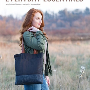 May include: A woman stands in a field, holding a black tote bag with a denim bottom and leather handles. The bag is part of a collection of accessories to sew and use. The text "EVERYDAY ESSENTIALS" and "noodlehead ANNA GRAHAM" are visible.