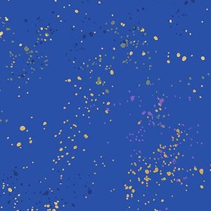 May include: A blue fabric with a speckled pattern of gold, purple, and green dots. The fabric has a ruler with the text "Ruby Star Society" printed on it.