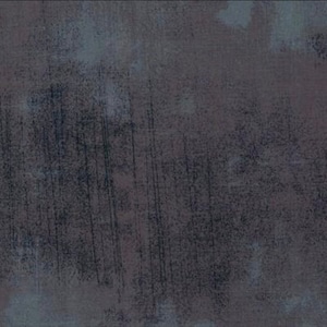 May include: A close-up of a textured, dark gray surface with vertical and diagonal streaks. The surface has a mottled appearance with hints of blue and brown, creating a weathered effect. The overall texture suggests a rough, industrial aesthetic.