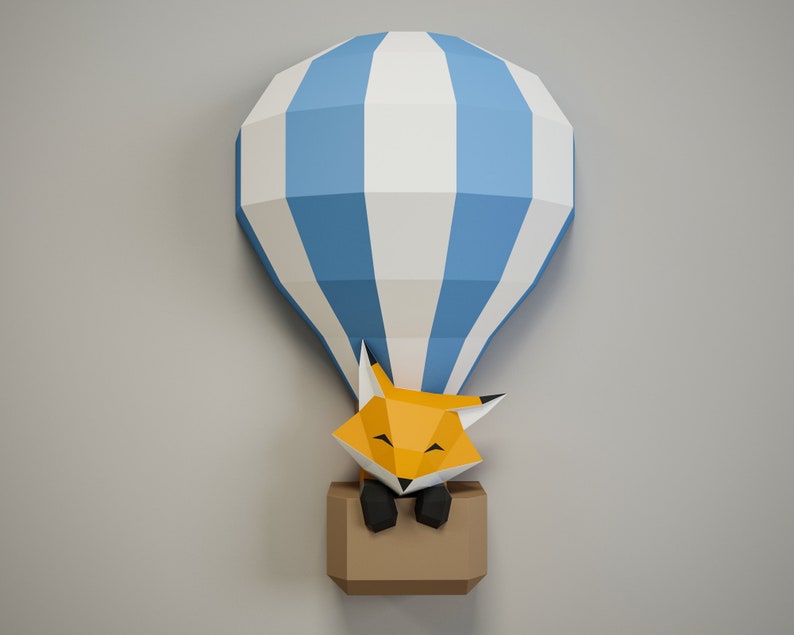 May include: A blue and white paper hot air balloon with a fox inside. The fox is orange and has black eyes and a black nose. The balloon is hanging from the ceiling.