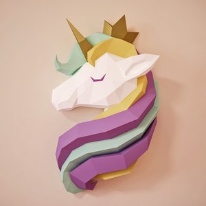 Könnte beinhalten: Ein geometrischer Papier-Einhornkopf mit goldenem Horn und Krone. Die Mähne hat Schichten aus Pastellfarben: Hellgrün, Gelb, Lila und Hellblau. Der Kopf des Einhorns ist weiß, mit geschlossenen lila Augen.