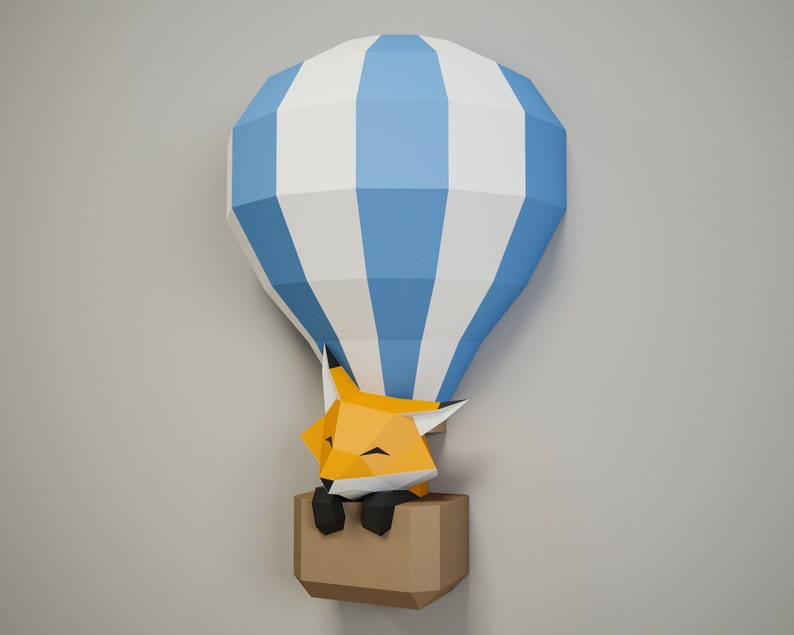 May include: A blue and white striped paper hot air balloon with a sleeping orange fox inside. The balloon is made of paper and has a brown paper basket.