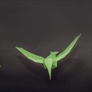 May include: Three origami paper birds in different colors: orange, green, and yellow. The birds are all facing forward and have their wings spread out.
