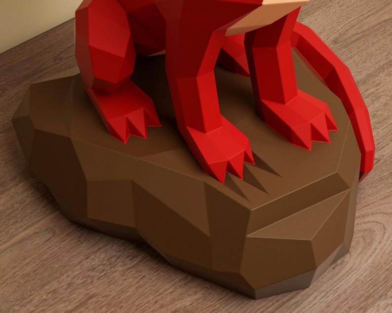 May include: A red, geometric sculpture of an animal, possibly a fox, sits on a brown, angular base. The sculpture's form is defined by sharp angles and facets, creating a modern, stylized aesthetic. The base has a faceted design. The sculpture is on a wooden surface.