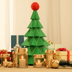 May include: A green paper Christmas tree with a red star on top, surrounded by wrapped presents and gold candle holders with lit candles.