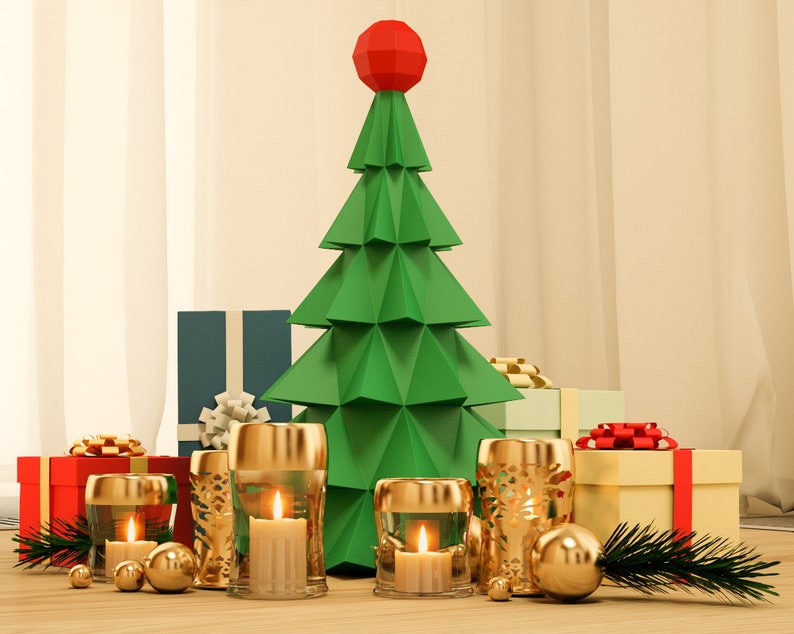 May include: A green paper Christmas tree with a red star on top, surrounded by wrapped presents and gold candle holders with lit candles.
