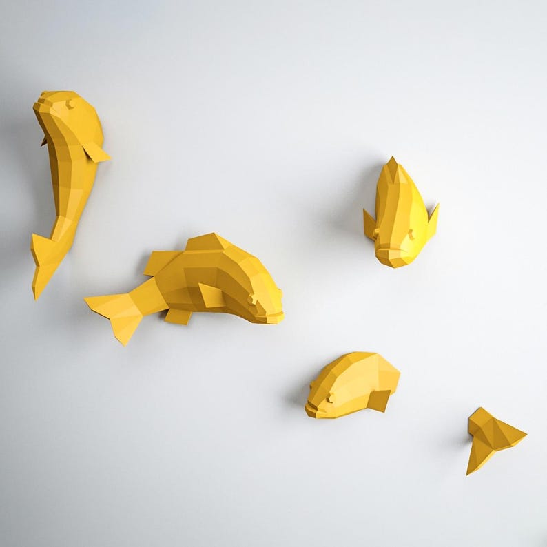 May include: Five yellow paper fish wall decorations. The fish are in various sizes and shapes, with some facing forward and others facing sideways. The fish are all made of folded paper and have a 3D effect.