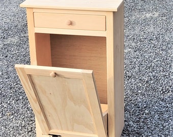 May include: A wooden cabinet with a single drawer and a drop-down door. The cabinet is made of unfinished pine wood and has black hinges.