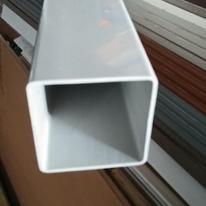 May include: A white square PVC pipe with a hollow center.