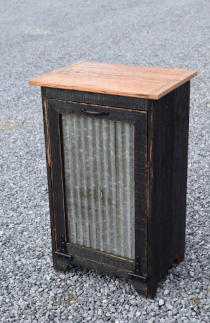 May include: A black wooden cabinet with a corrugated metal door and a wood top. The cabinet has black metal hinges and a black metal handle.
