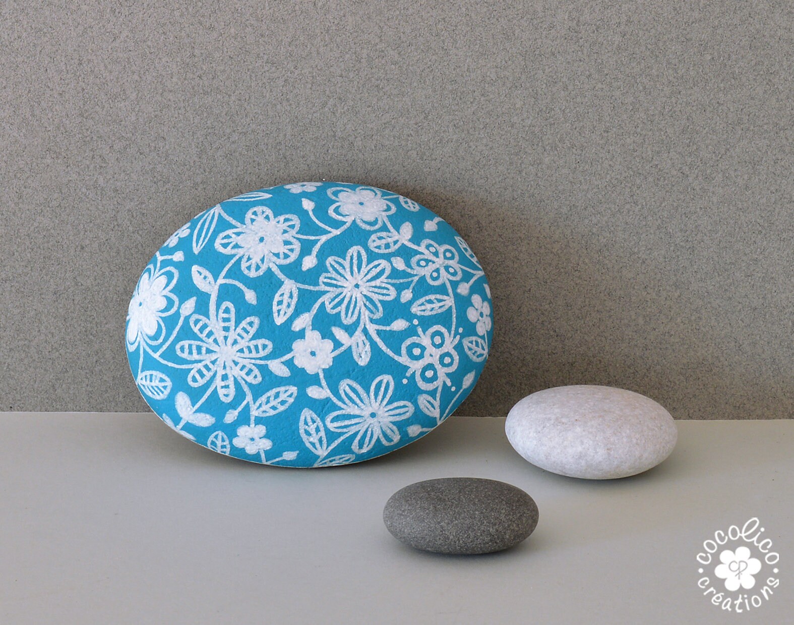 Galet Peint Fleurs Blanches sur Fond Bleu Turquoise