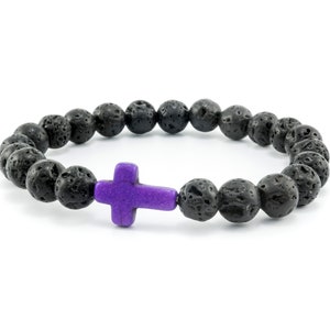 May include: A black lava rock beaded bracelet with a purple cross charm.