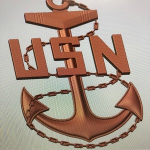 Puede incluir: Un ancla de metal de color bronce con una cadena envuelta alrededor. El ancla tiene una textura de cuerda y las letras "USN" están en relieve en la parte superior del ancla.