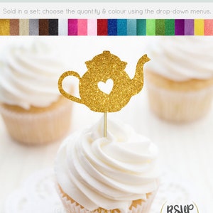 May include: A gold glitter cardstock cupcake topper shaped like a teapot with a heart, placed on a cupcake with white icing. The image shows other cupcakes and text that reads "Cupcake Toppers/Food Picks - Glitter Cardstock".