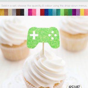 May include: Green glitter cardstock cupcake topper shaped like a video game controller. The topper is on a toothpick and is ready to be placed on a cupcake.