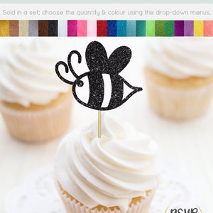May include: Black glitter bee cupcake topper with white stripes. The bee is on a wooden stick and is ready to be placed on a cupcake. The cupcake topper is sold in a set and is available in a variety of colors.