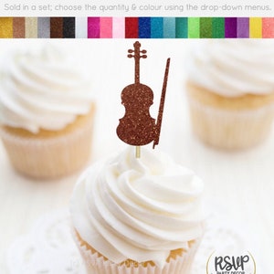 Puede incluir: Un conjunto de adornos para cupcakes con un violín de purpurina marrón con arco. Los adornos se venden en un conjunto y están disponibles en una variedad de colores. "Se vende en un conjunto; elige la cantidad y el color usando los menús desplegables."  "RSVP Party Decor" está impreso en la esquina inferior derecha de la imagen.