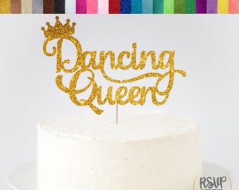 May include: Gold glitter cardstock cake topper with the words "Dancing Queen" and a crown.