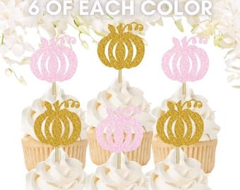 Peut inclure: Six décorations pour cupcakes en forme de citrouilles pailletées dorées et rose clair. Chaque citrouille est fixée sur un fin pic en bois. Le texte 6 OF EACH COLOR est affiché en haut. Les décorations sont insérées dans six cupcakes au glaçage blanc.