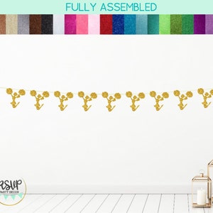 May include: Gold glitter cheerleading banner with the text "RSVP Party Decor" in a white circle with a teal border. The banner features eight cheerleaders holding pom-poms.