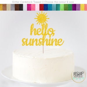 May include: Gold glitter cardstock cake topper with a sun and the words "hello sunshine".