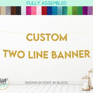 May include: Gold glitter banner with the text "CUSTOM TWO LINE BANNER" in a block font. The banner is fully assembled and ready to hang.