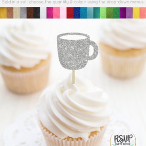Könnte beinhalten: Silberner Glitzer-Cupcake-Topper in Form einer Kaffeetasse. Der Topper befindet sich auf einem weißen Cupcake mit weißem Frosting. Der Cupcake steht auf einer weißen Spitze. Der Text "RSVP Party Decor" ist auf dem Bild zu sehen.