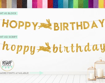 Puede incluir: Bandera de brillo dorado con las palabras "HOPPY BIRTHDAY" en letras de bloque y "hoppy birthday" en letras de escritura. La bandera presenta una silueta de conejo entre las palabras.
