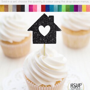 May include: Black glitter cupcake topper shaped like a house with a white heart cutout. The topper is on a cupcake with white frosting. The text "RSUP PARTY DECOR" is visible in the lower right corner of the image.