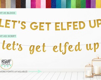 May include: Gold glitter banner with the phrase "LET'S GET ELFED UP" in block letters and script. The banner is strung on a thin wire, with a white background. The image also shows a variety of glitter colors.