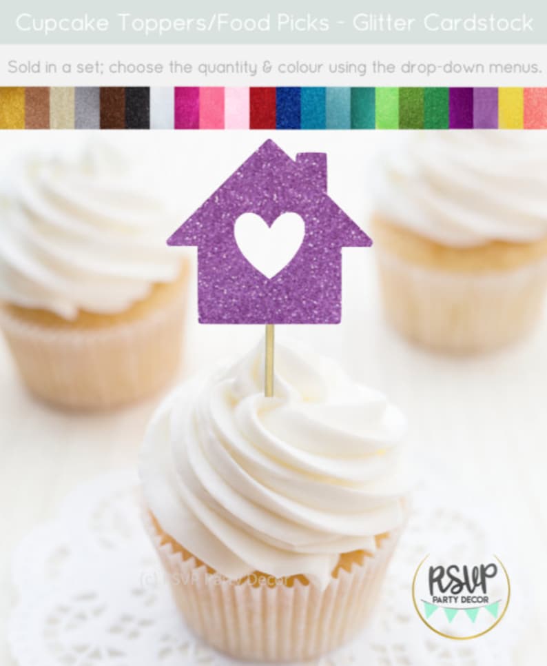 May include: Purple glitter cupcake topper shaped like a house with a white heart in the center. The topper is on a cupcake with white frosting. The text "RSUP PARTY DECOR" is visible in the bottom right corner of the image.