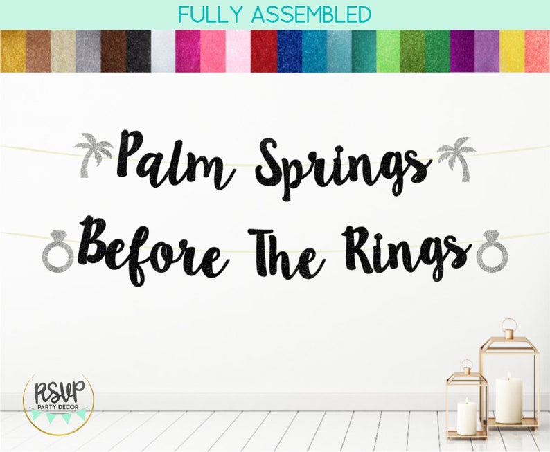 May include: Black glitter banner with the text "Palm Springs Before The Rings" with silver glitter palm trees and ring icons.