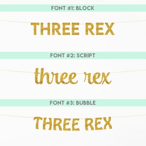 May include: Three different font styles for the phrase "Three Rex" are shown on a banner. The fonts are block, script, and bubble. The banner is gold glitter.