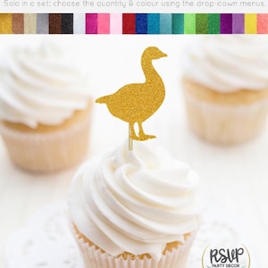 May include: Gold glitter goose cupcake topper. The topper is on a cupcake with white frosting. The cupcake is on a white doily. The text "RSUP PARTY DECOR" is on a white circle with a gold border.