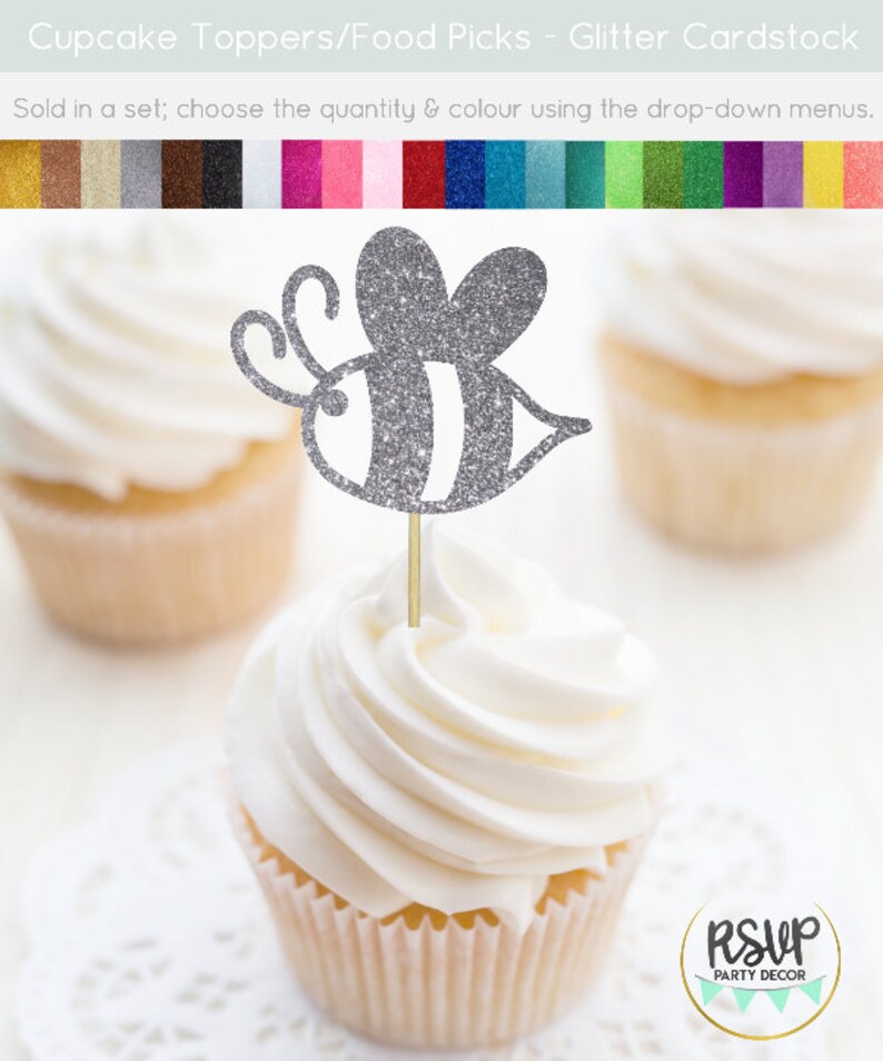 May include: Silver glitter bee cupcake topper. The bee has black and white stripes. The topper is on a cupcake with white frosting. The cupcake is on a white doily. The text "RSUP PARTY DECOR" is in the lower right corner of the image.