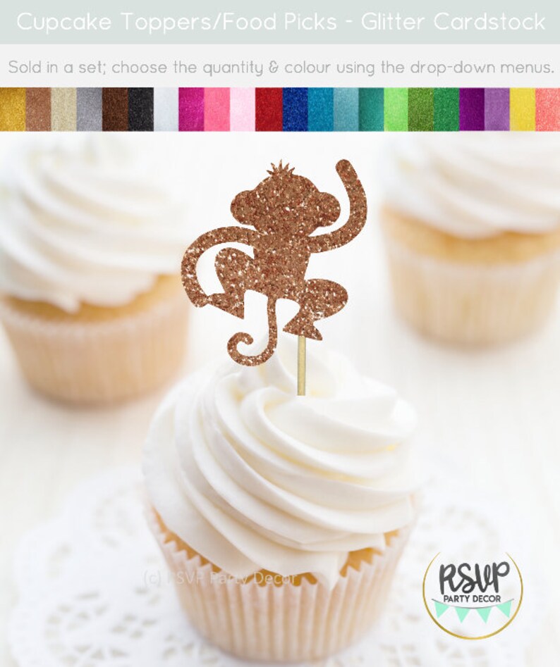 K&ouml;nnte beinhalten: Goldener Glitzer-Affen-Cupcake-Topper. Der Affe sitzt mit erhobenen Armen und seinem Schwanz um sein Bein gewickelt. Der Topper befindet sich auf einem wei&szlig;en Cupcake mit wei&szlig;em Frosting.