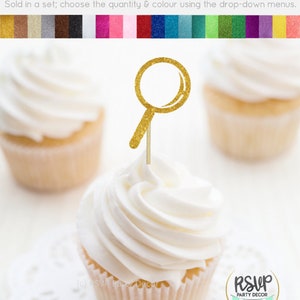 K&ouml;nnte beinhalten: Goldener Glitzer-Lupe-Cupcake-Topper. Der Topper befindet sich auf einem wei&szlig;en Cupcake mit wei&szlig;em Frosting. Der Cupcake steht auf einer wei&szlig;en Spitze. Der Text "RSVP Party Decor" ist in der unteren rechten Ecke des Bildes sichtbar.